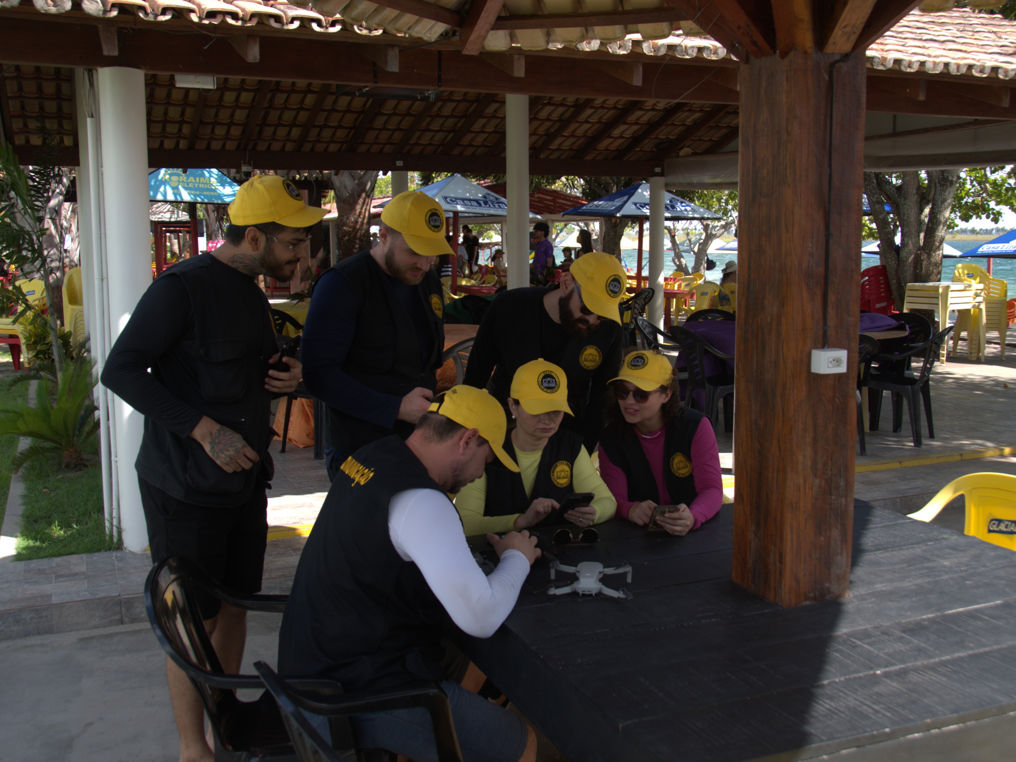 Imagem colorida da equipe de comunicação atuando em ambiente externo 