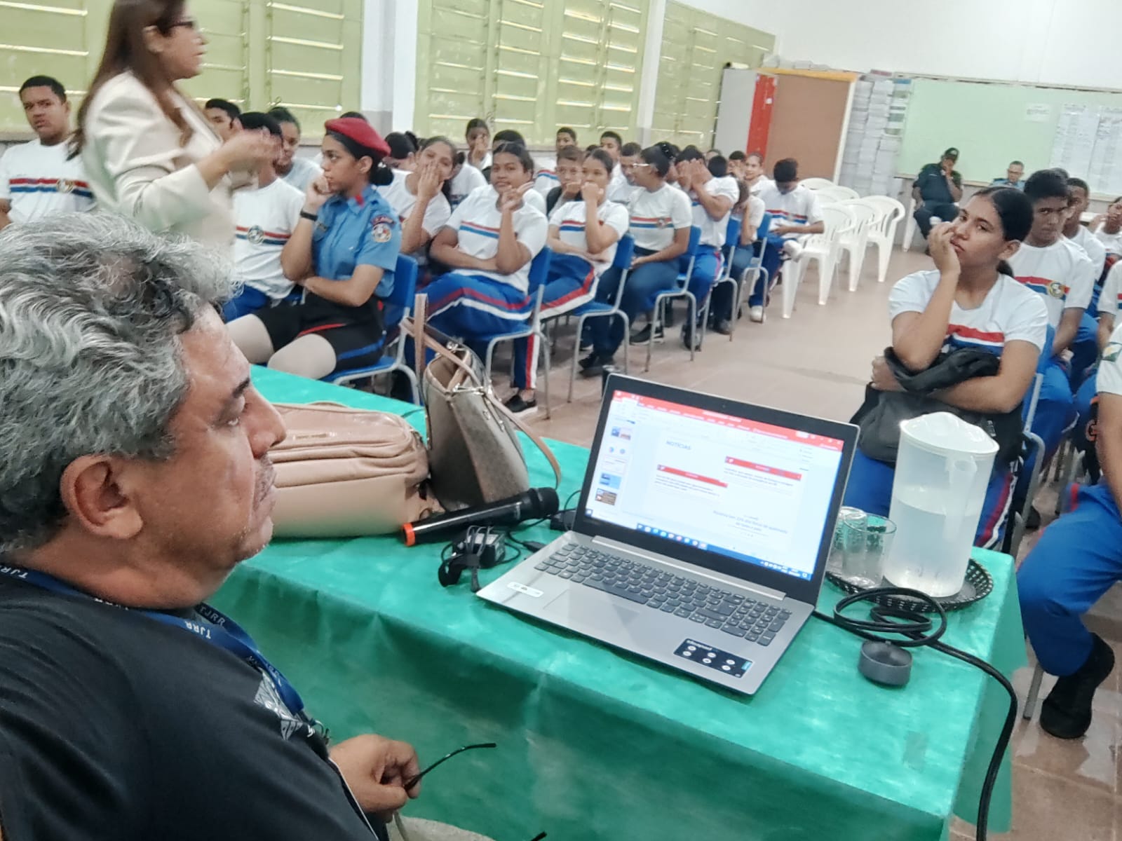 foto colorida de alunos sentados dentro da sala de aula , assitindo uma palestra