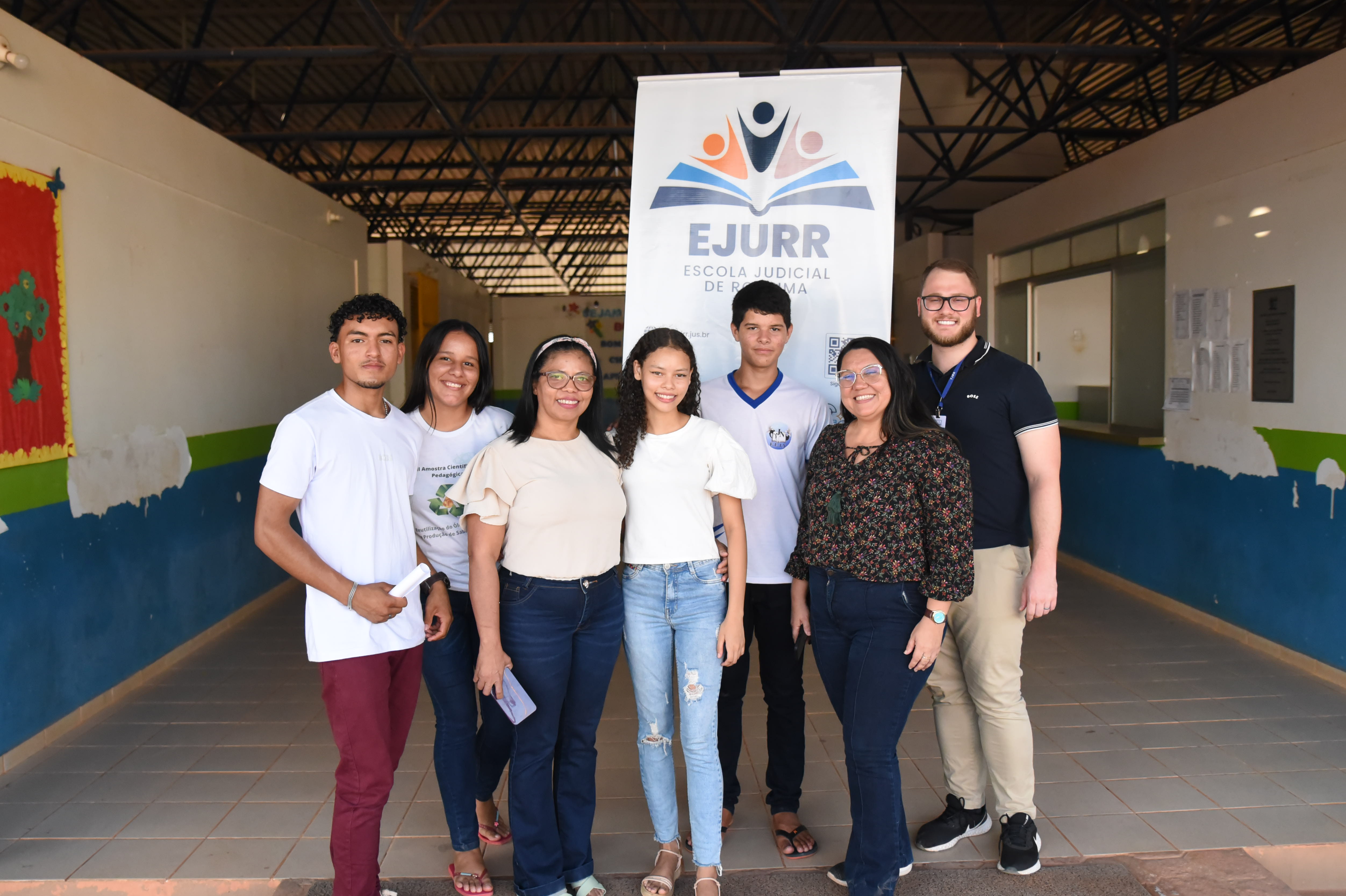Imagem colorida mostra alunos e representante da Escola Estadual Joaquim Nabuco posando para foto.