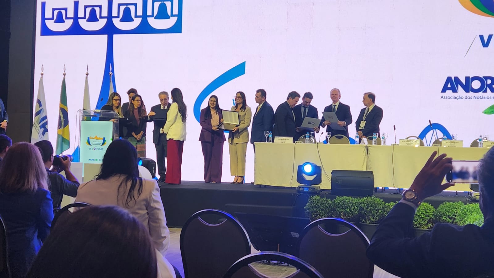 Foto colorida mostra a servidora do TJRR, Luciana Menezes recebendo premiação em homenagem ao desembargador Mozarildo Cavalcanti, durante congresso nacional Anoreg/BR.