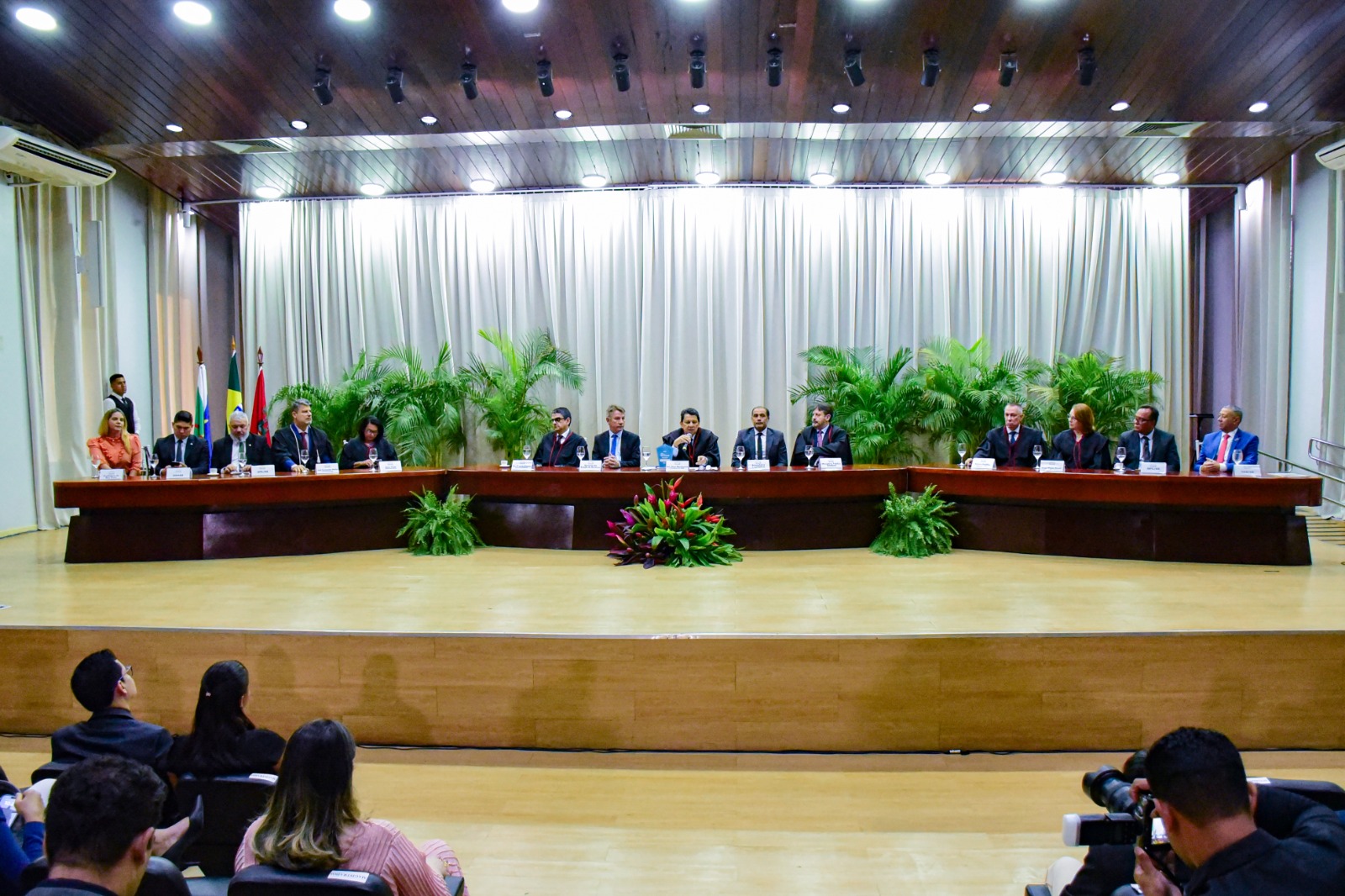 foto colorida da mesa de autoridades do evento que estão dentro do fórum cível