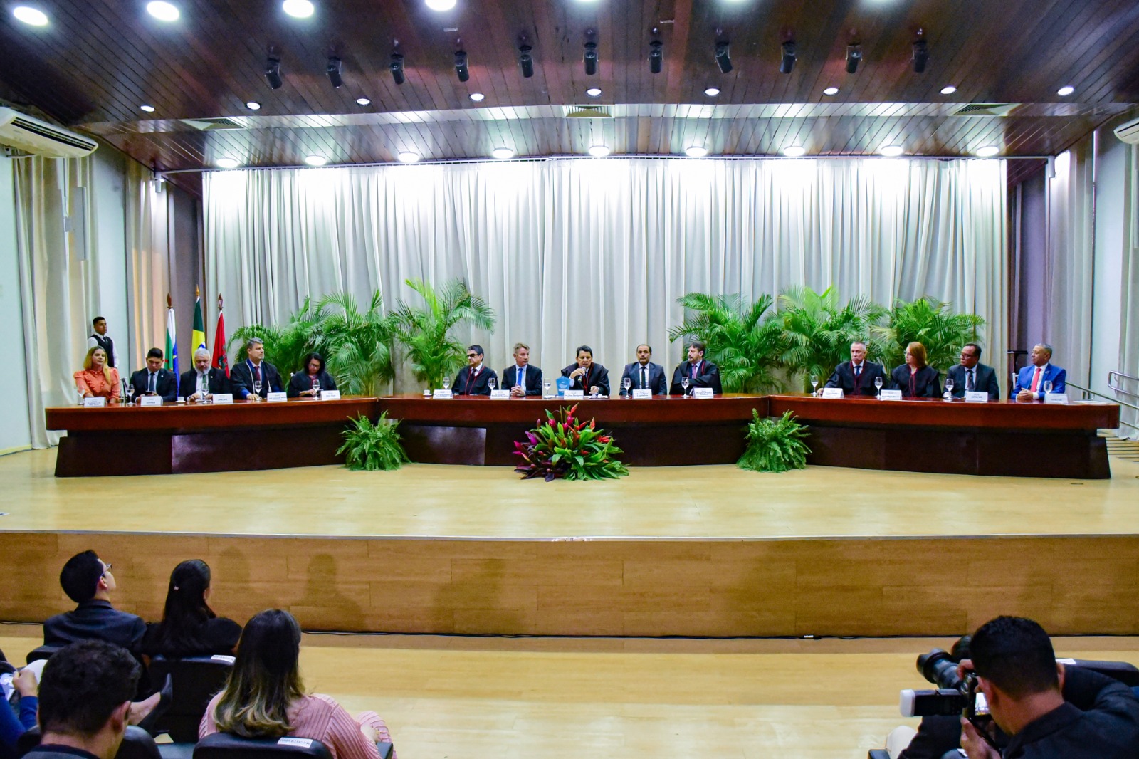 foto colorida da mesa de autoridades do evento que estão dentro do fórum cível 