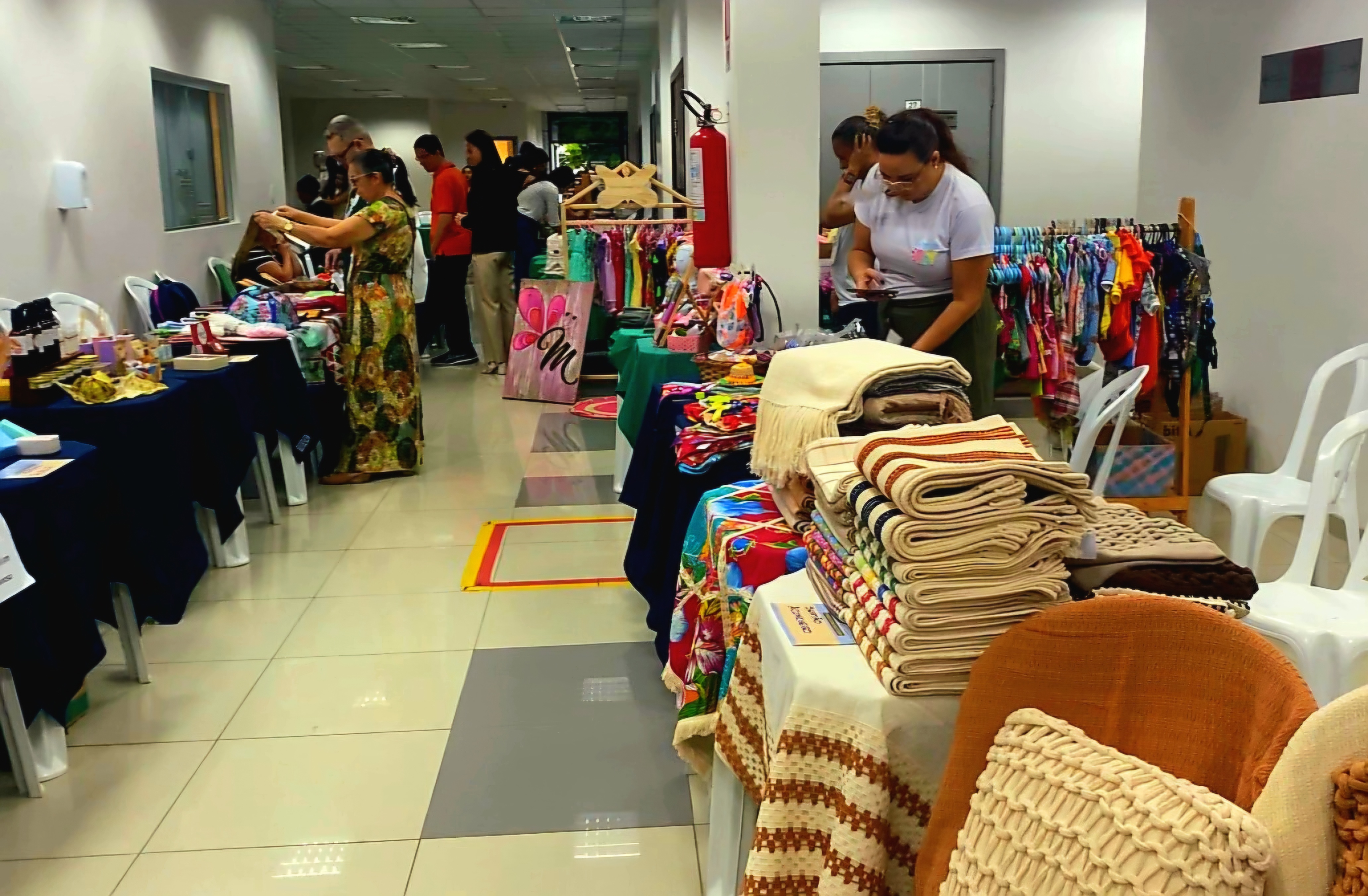 Imagem colorida mostrando vários produtos sendo comercializados, entre eles roupas, bolsas e etc