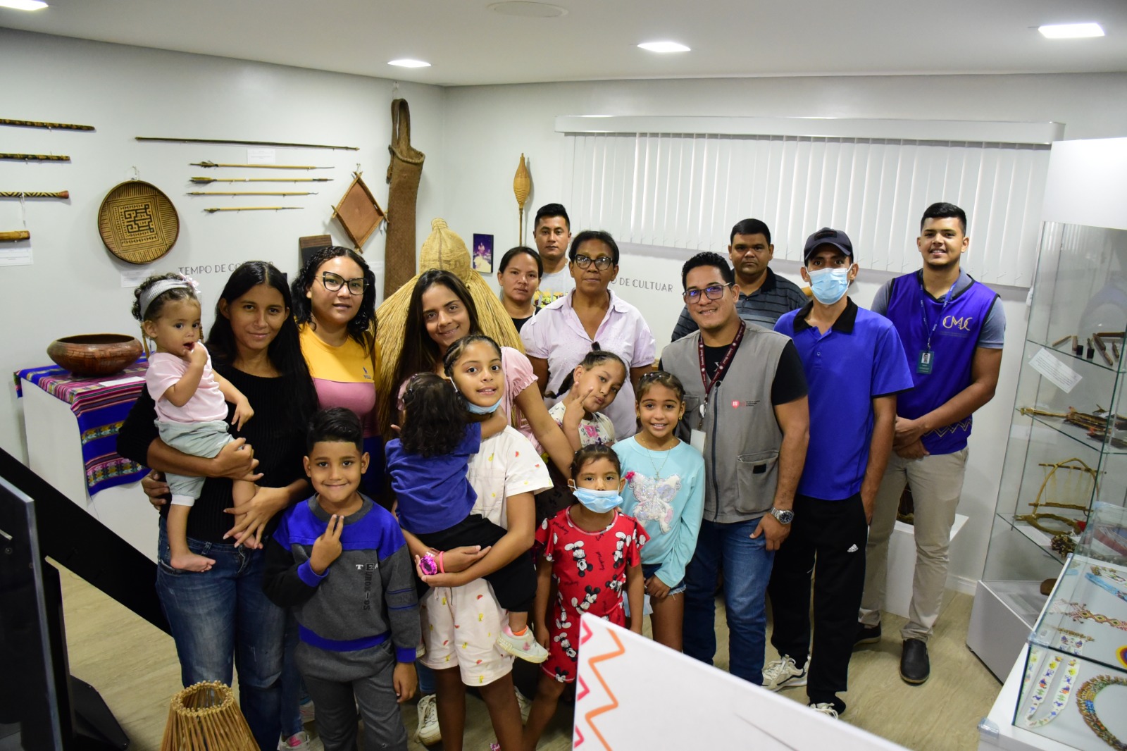 Foto colorida mostra um grupo de 17 pessoas posando para fotografia, entre 16 integrantes da Fundação de imigrantes Fé e Alegria, e um colaborador do Centro de Memória e Cultura do Poder Judiciário de Roraima (CMC/TJRR), posando para fotografia durante visita guiada ao CMC/TJRR.