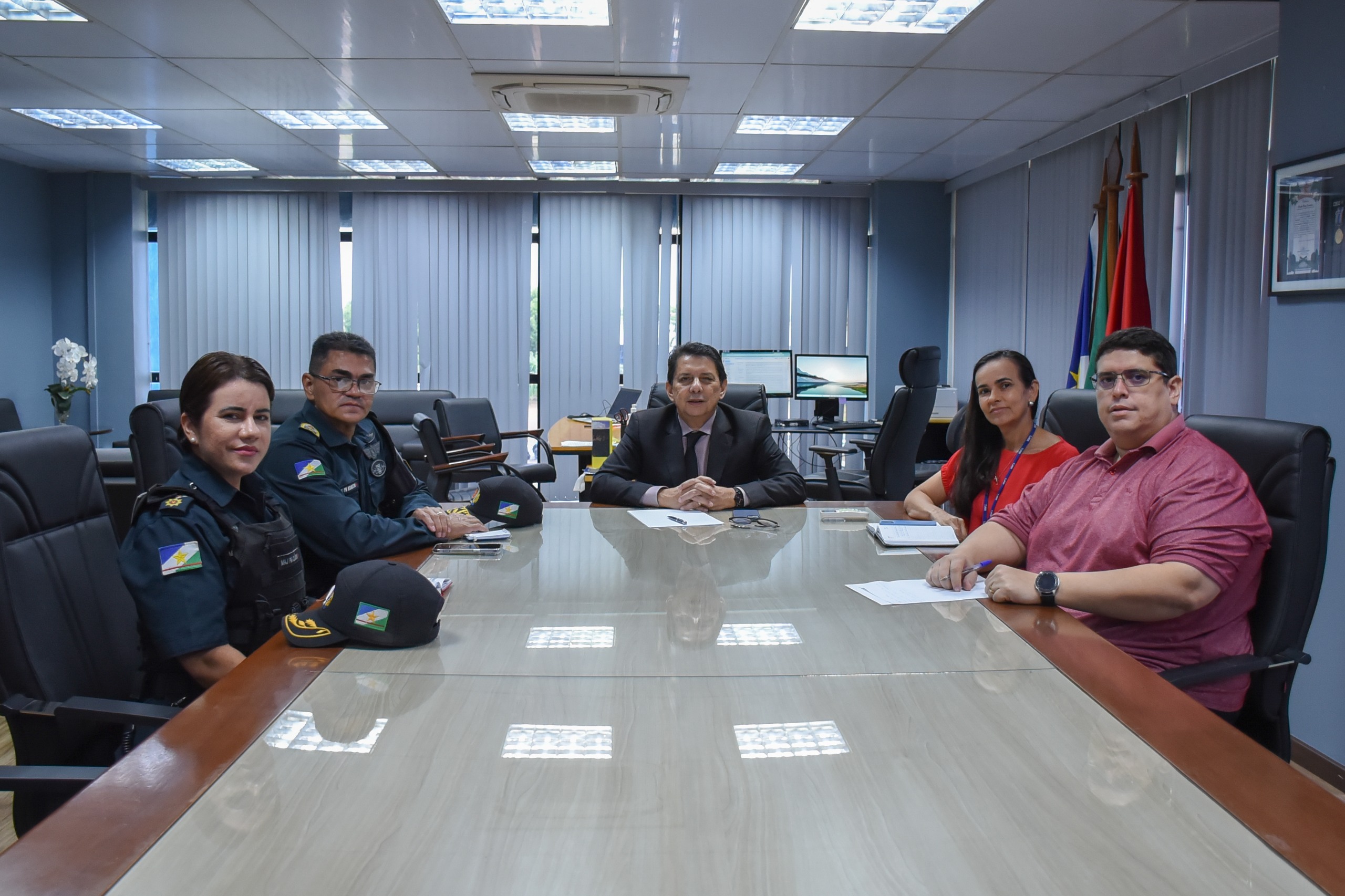 Imagem colorida mostra cinco pessoas reunidas sentadas em volta de uma mesa, que inclui desembargador Jésus Nascimento, o comandante da Polícia Militar de Roraima, coronel Miramilton Goiano de Souza, além dos assessores da Presidência.