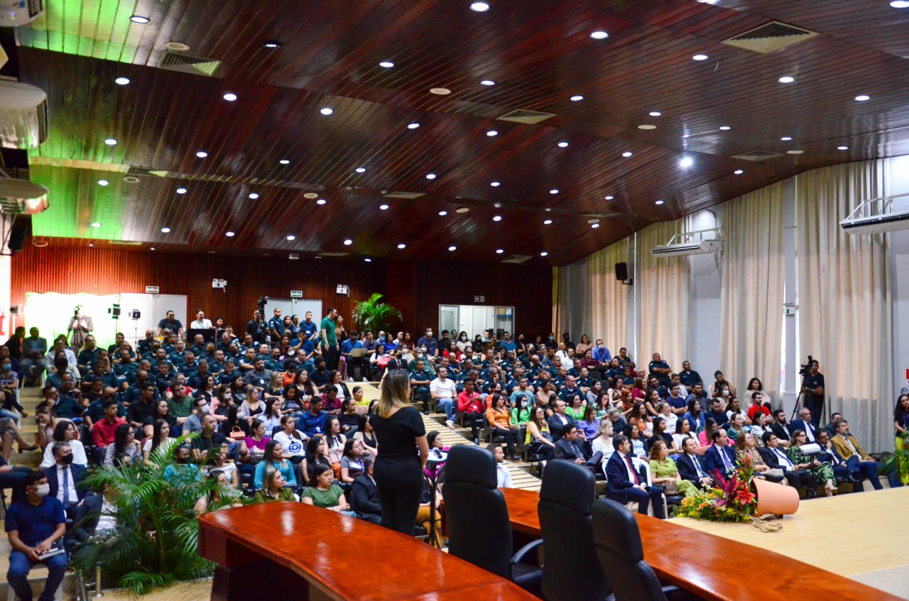 Imagem mostra auditório lotado, com aproximadamente 300 pessoas. 