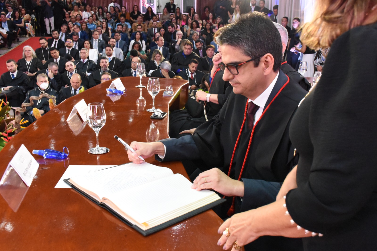 Imagem colorida mostra o vice-presidente do Tribunal de Justiça de Roraima, desembargador Ricardo Aguiar, assinando o termo de posse.