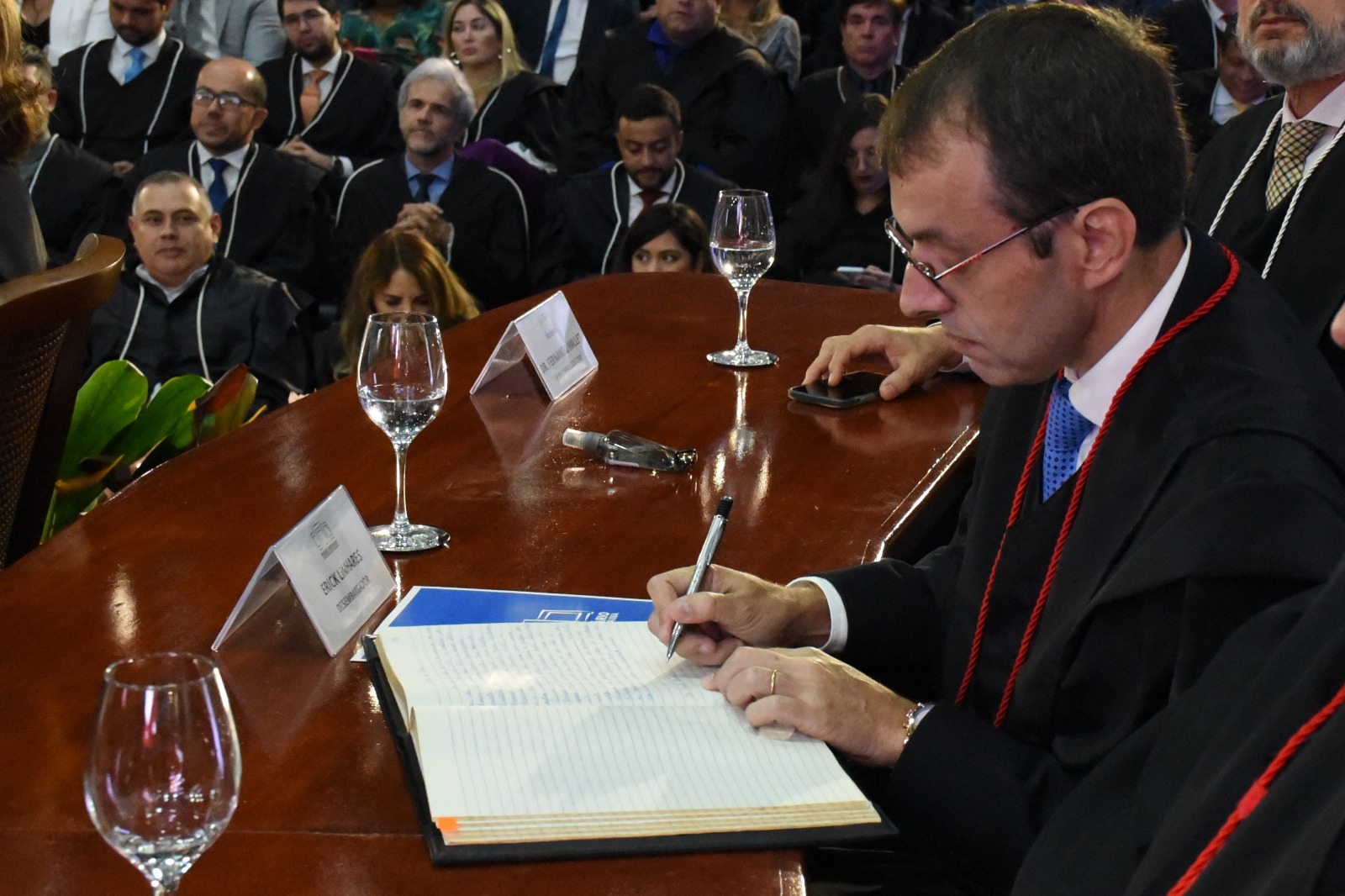 Imagem colorida mostra o ouvidor-geral do Tribunal de Justiça de Roraima, desembargador Erick Linhares, assinando o termo de posse.