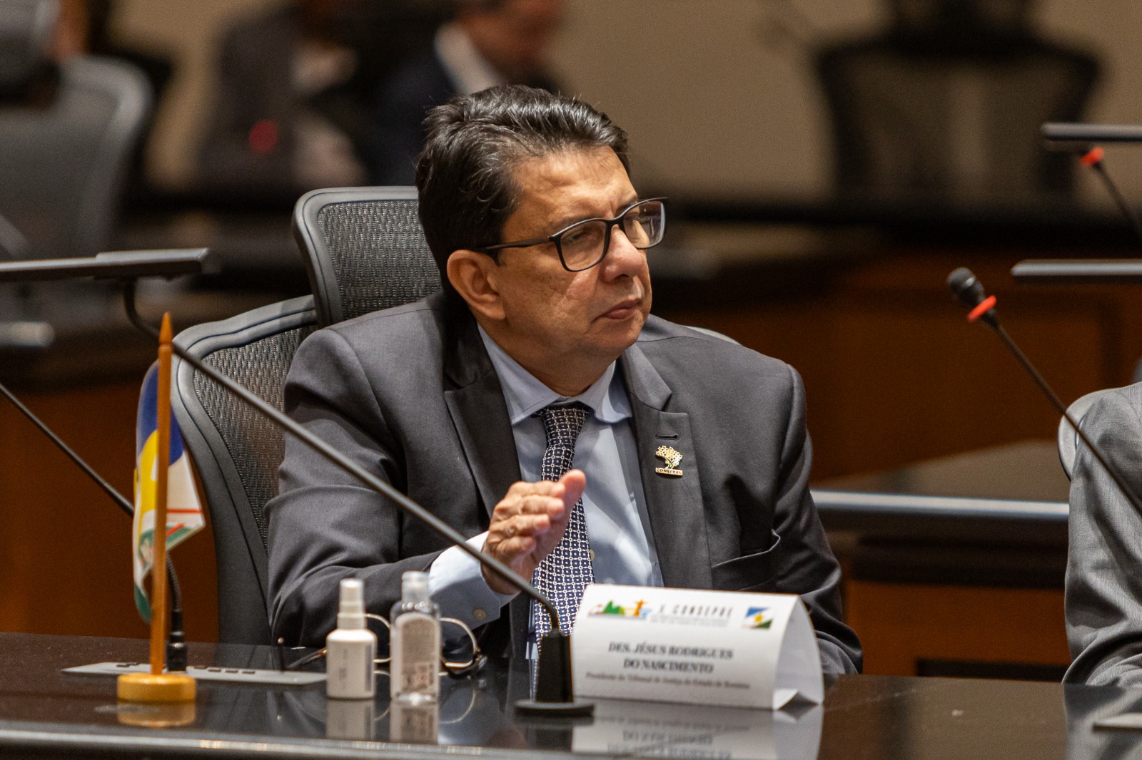 Foto colorida mostra em ângulo fechado, o presidente do Tribunal de Justiça de Roraima, desembargador Jésus Nascimento sentado em uma cadeira atrás da mesa durante o evento.