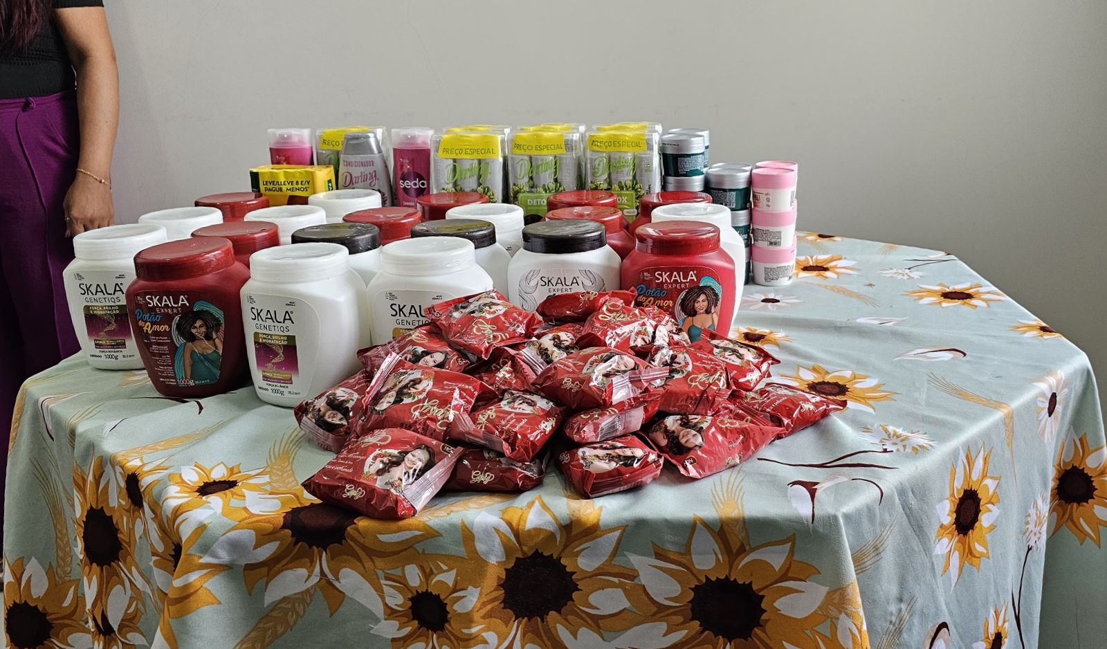 Foto colorida mostra mesa com produtos de higiene física doados.