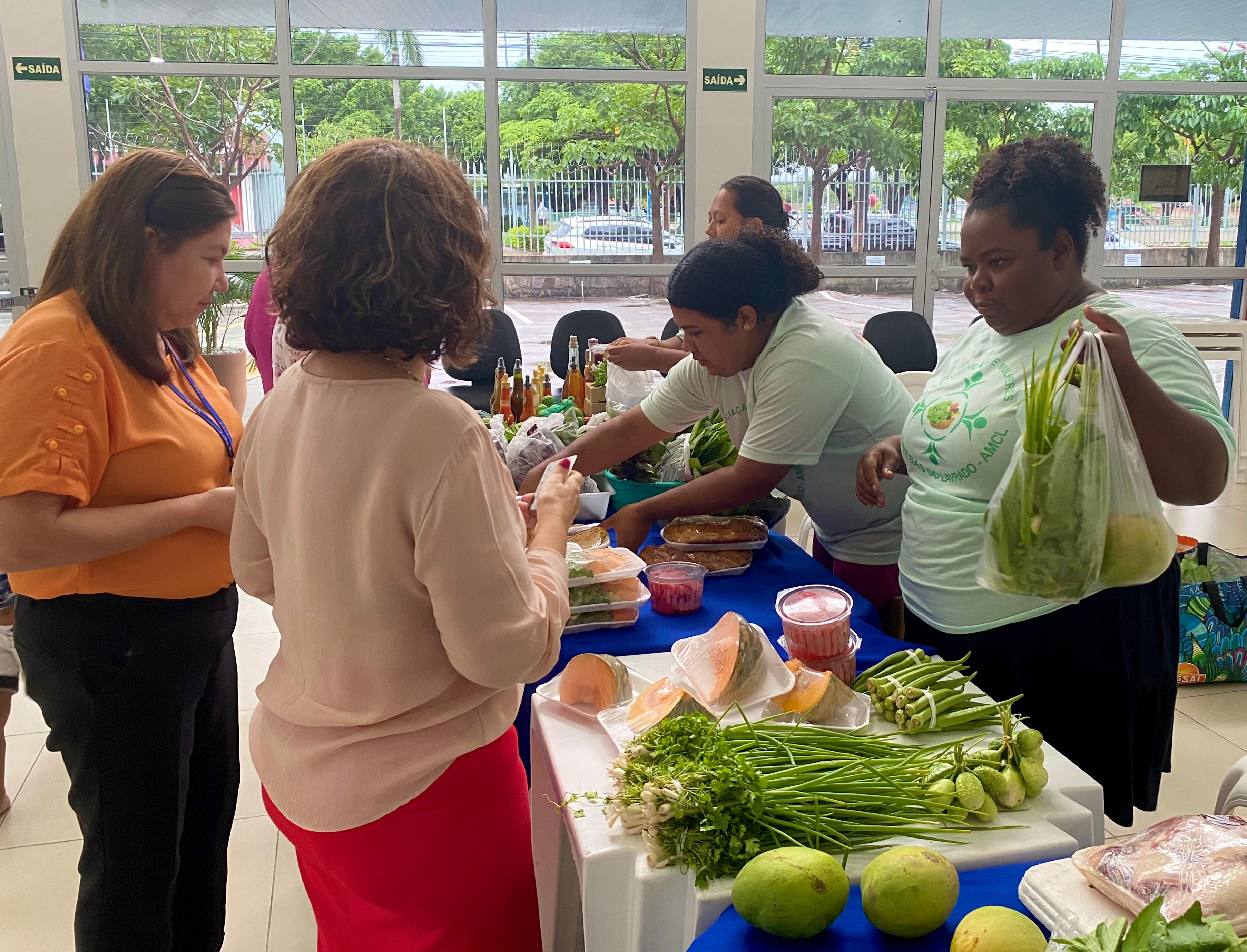 Foto mostrando as Camponesas do Lavrado comercializando produtos naturais no prédio Administrativo