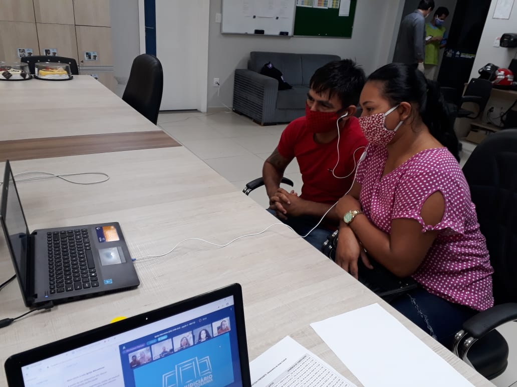 Casal em frente am uma tela de computador para realizar a união estável por meio virtual.