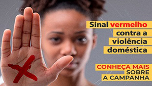 Imagem de uma mulher com a mão a frente e um x pintado em vermelho na palma de sua mão. Texto ao lado: Sinal Vermelho contra a violência doméstica