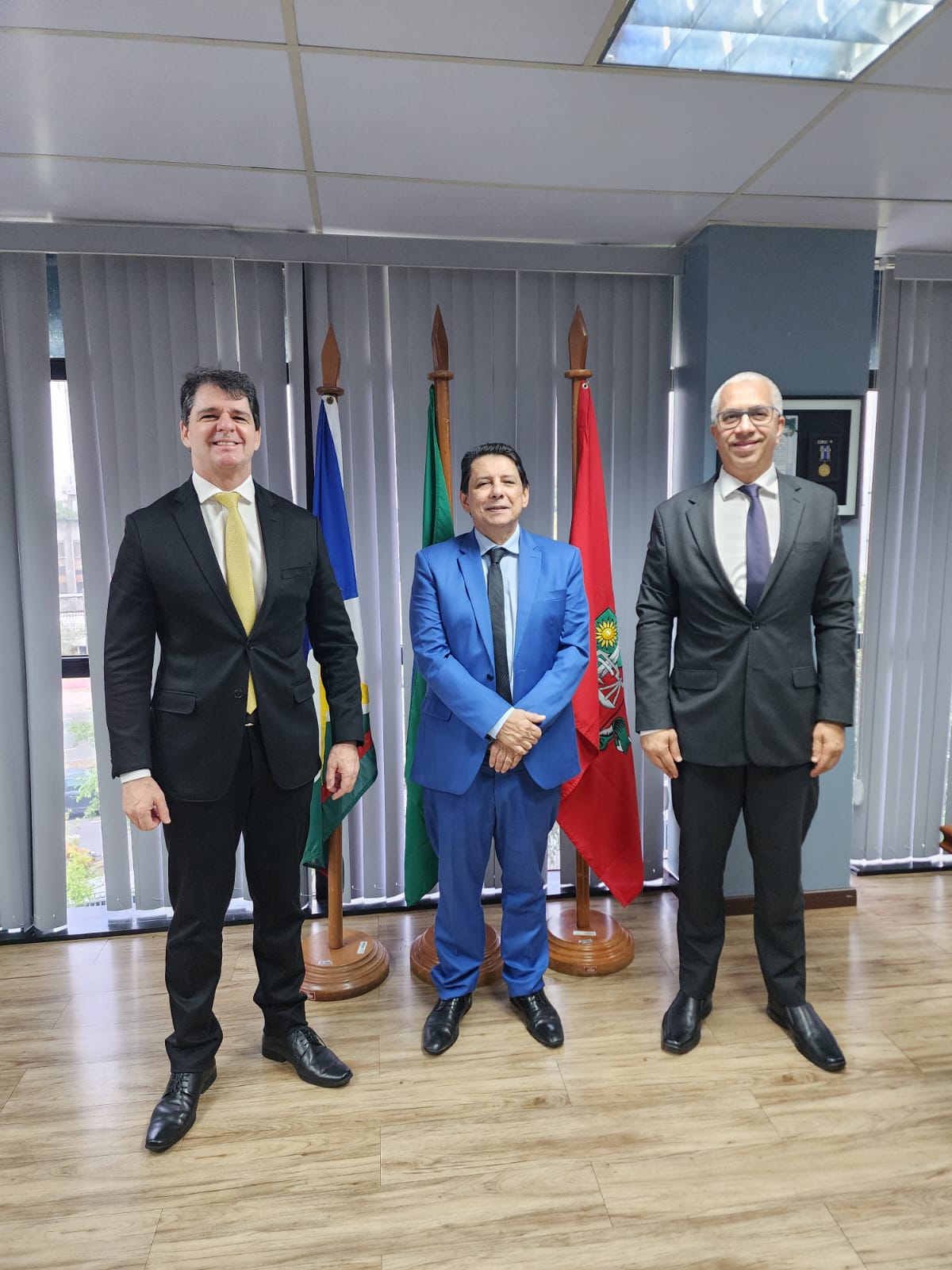 Foto colorida mostra o presidente do Tribunal de Justiça de Roraima, desembargador Jésus Nascimento, o superintendente regional da Polícia Federal em Roraima, Ronaldo Guilherme Campos, o delegado Carlos Henrique Macedo, diretor regional executivo no Estado de pé posando para foto.