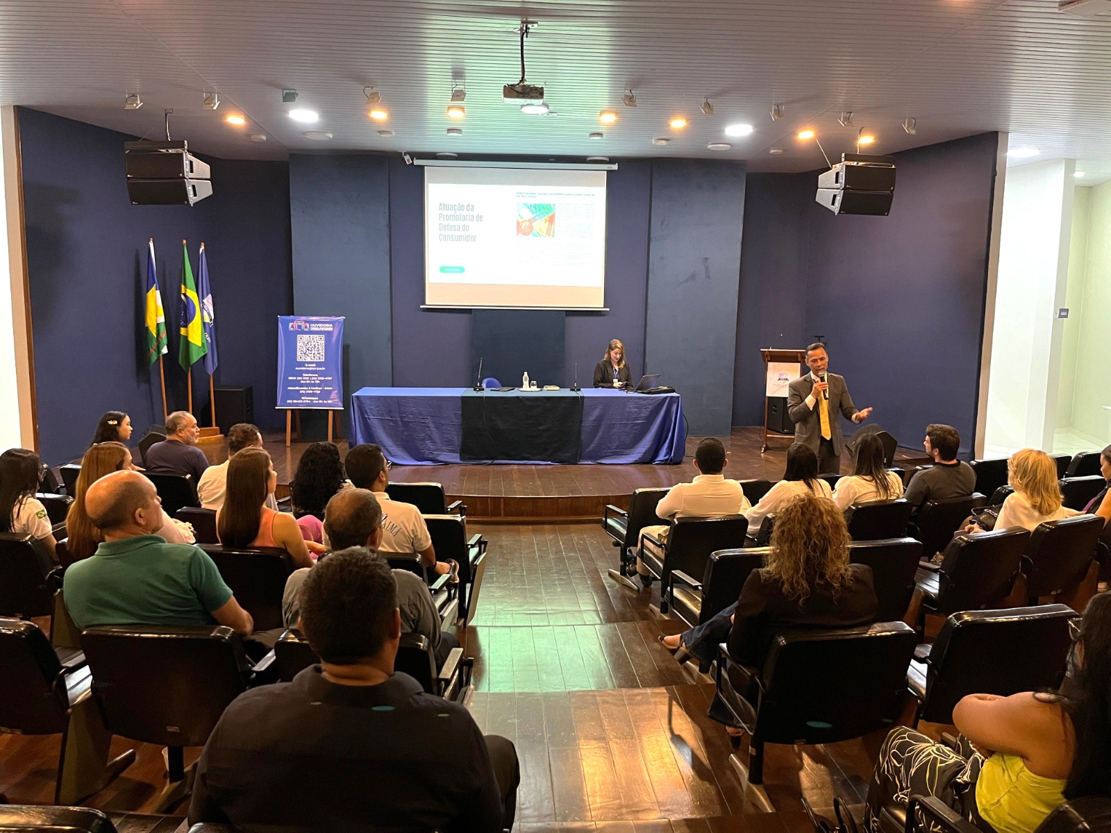 foto colorida de uma pessoa palestrando com microfone em auditório