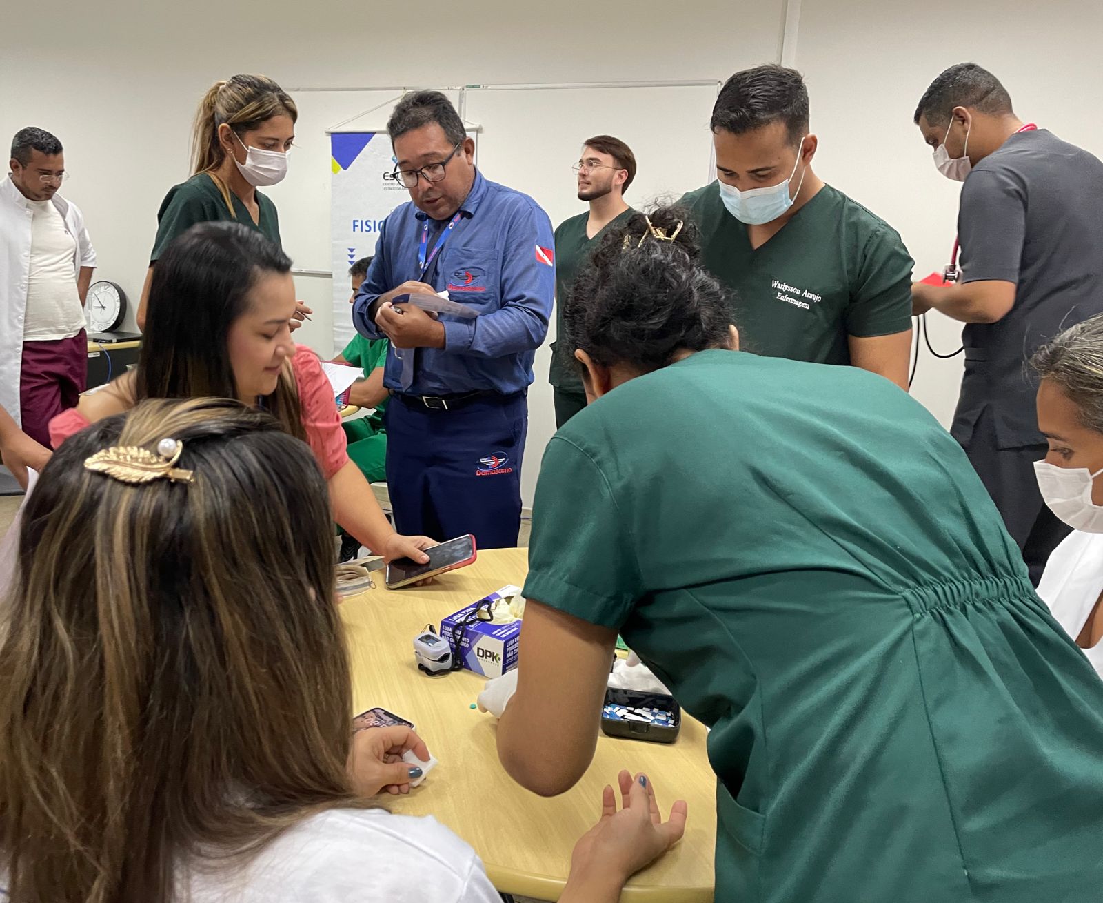 Imagem colorida mostra pessoas sendo atendidas pelos profissionais presentes.