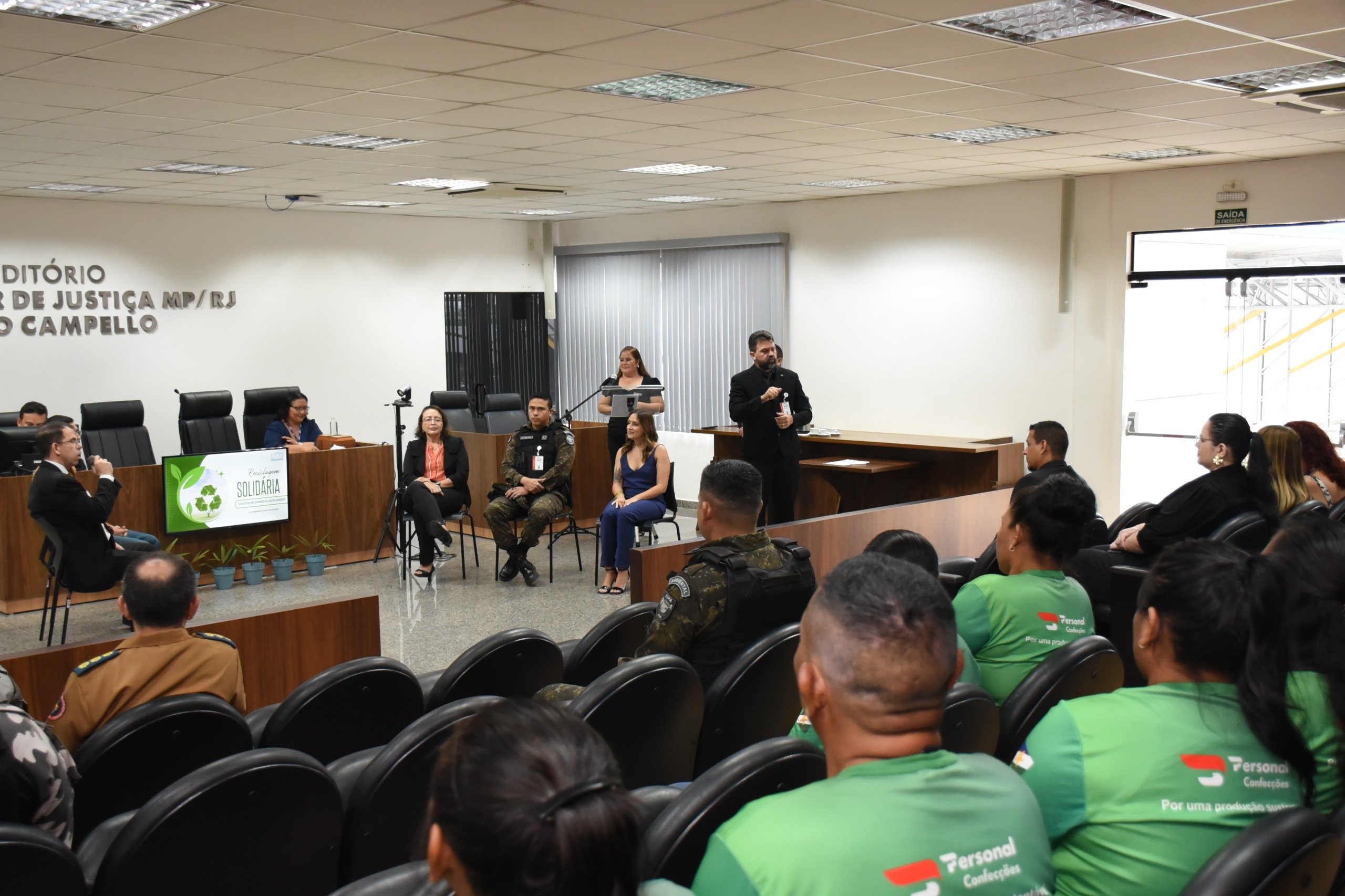 Imagem colorida mostrando pessoas sentadas em um auditório