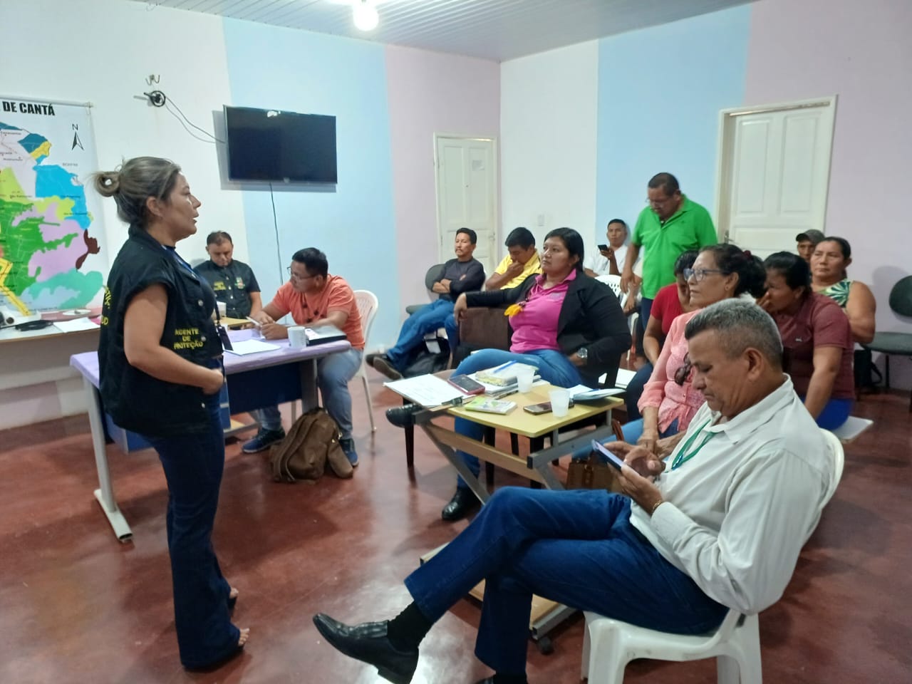 Imagem colorida mostra pessoas sentadas esperando atendimento.