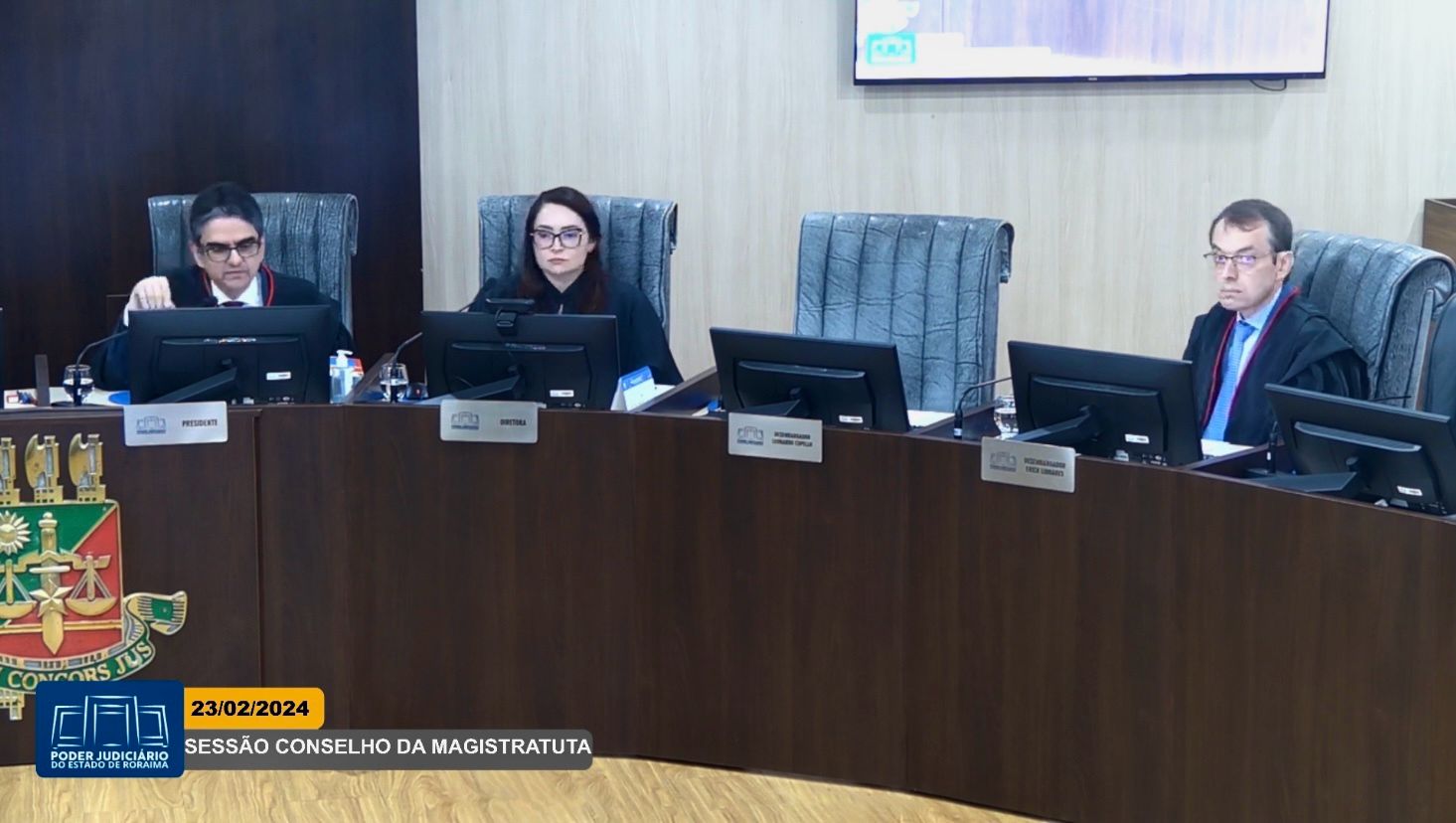 Foto colorida com três pessoas em um semicírculo na mesa na 1ª Sessão Ordinária do Conselho da Magistratura. Da esquerda para a direita está o Desembargador Ricardo Oliveira, a Chefe da Secretaria do Tribunal Pleno Michelle Miranda de Albuquerque e o Desembargador Erick Linhares.