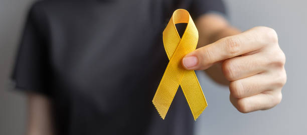 foto ilustrativa de uma pessoa segurando um laço amarelo